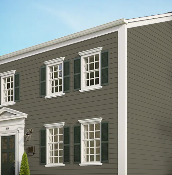 A brown house with white trim and green shutters