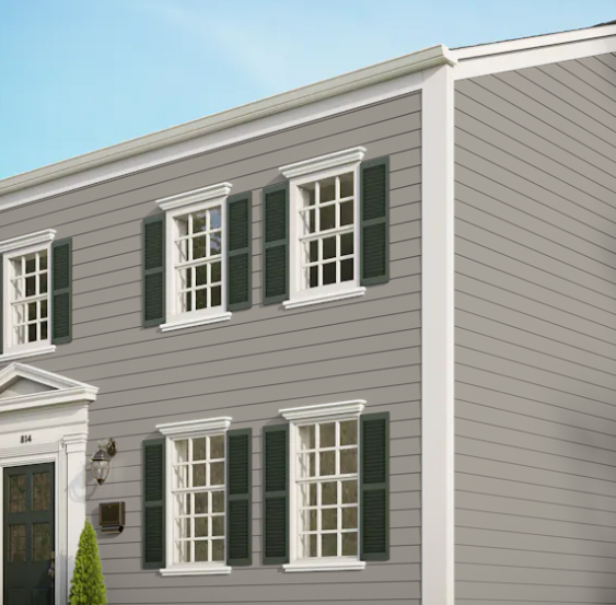 A grey house with white trim and green shutters