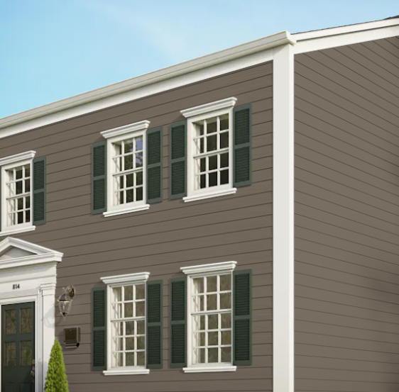 A brown house with white trim and green shutters