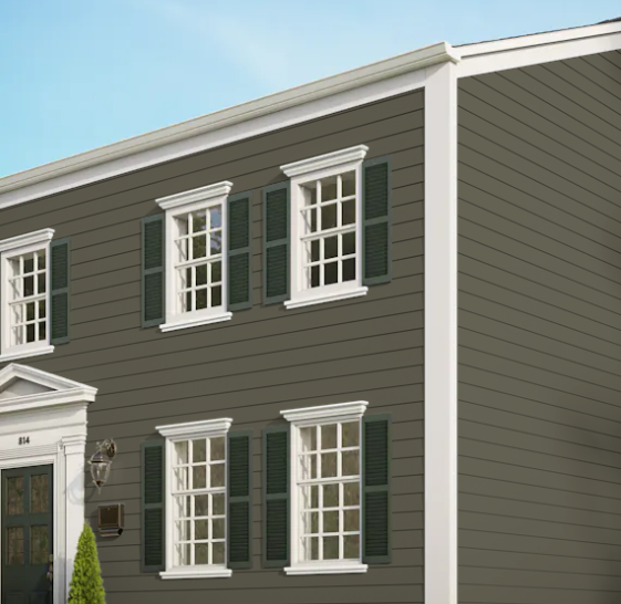 A brown house with white trim and green shutters