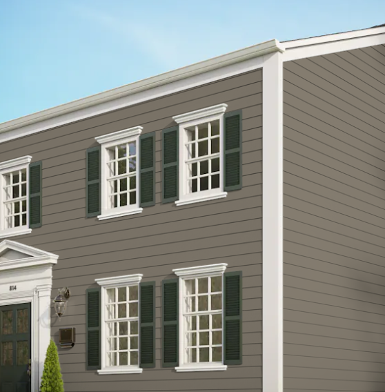 A brown house with white trim and green shutters