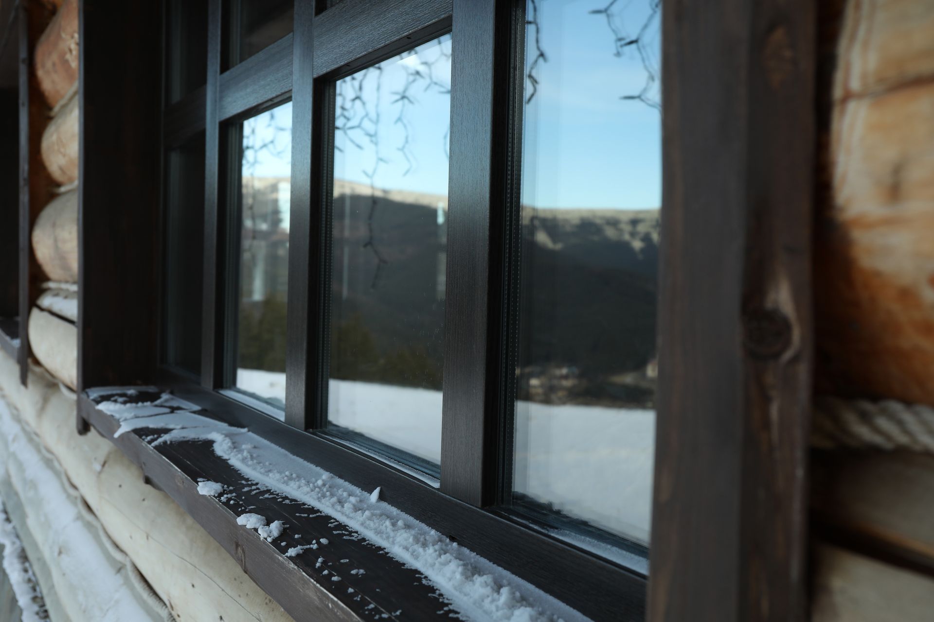 Insulated vinyl window on snowy Colorado log home