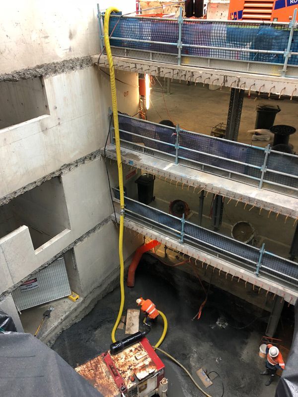 a large building under construction with a yellow hose coming out of it .