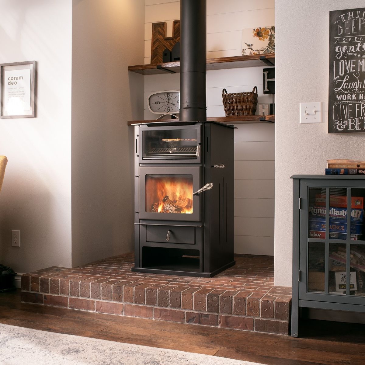 A wood stove in a living room with a sign on the wall that says