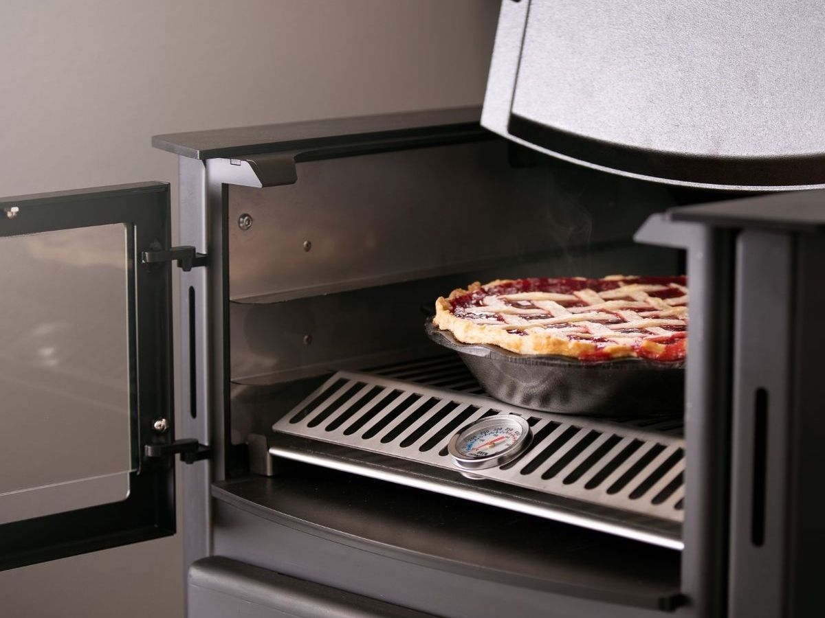 A pie is cooking in an oven with the door open