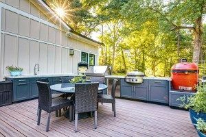 A patio with a table and chairs and a grill.