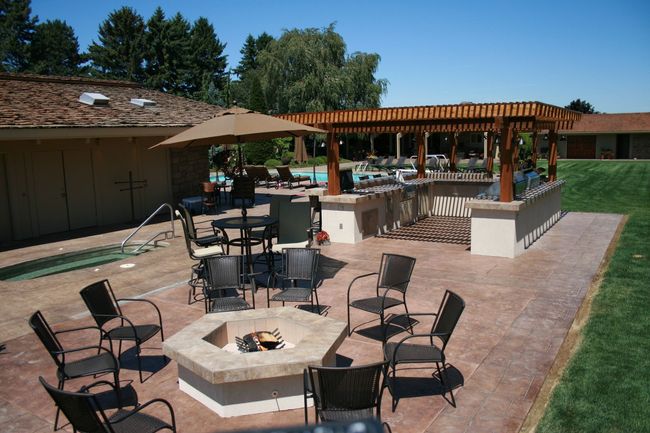 A fire pit is surrounded by chairs and tables