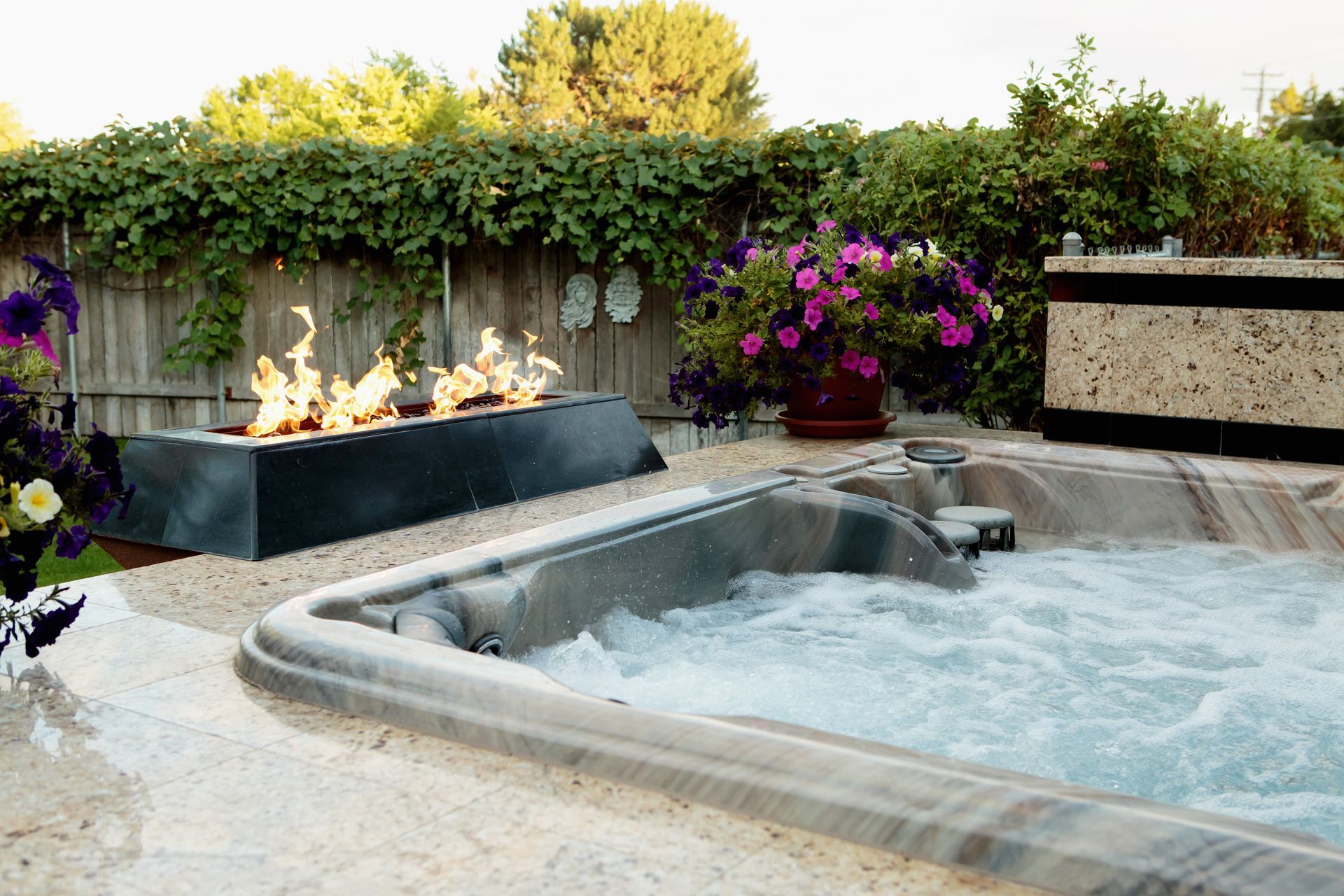 A hot tub with a fire pit in the background