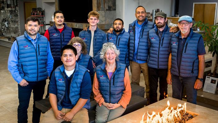 A group of people are posing for a picture in front of a fireplace.