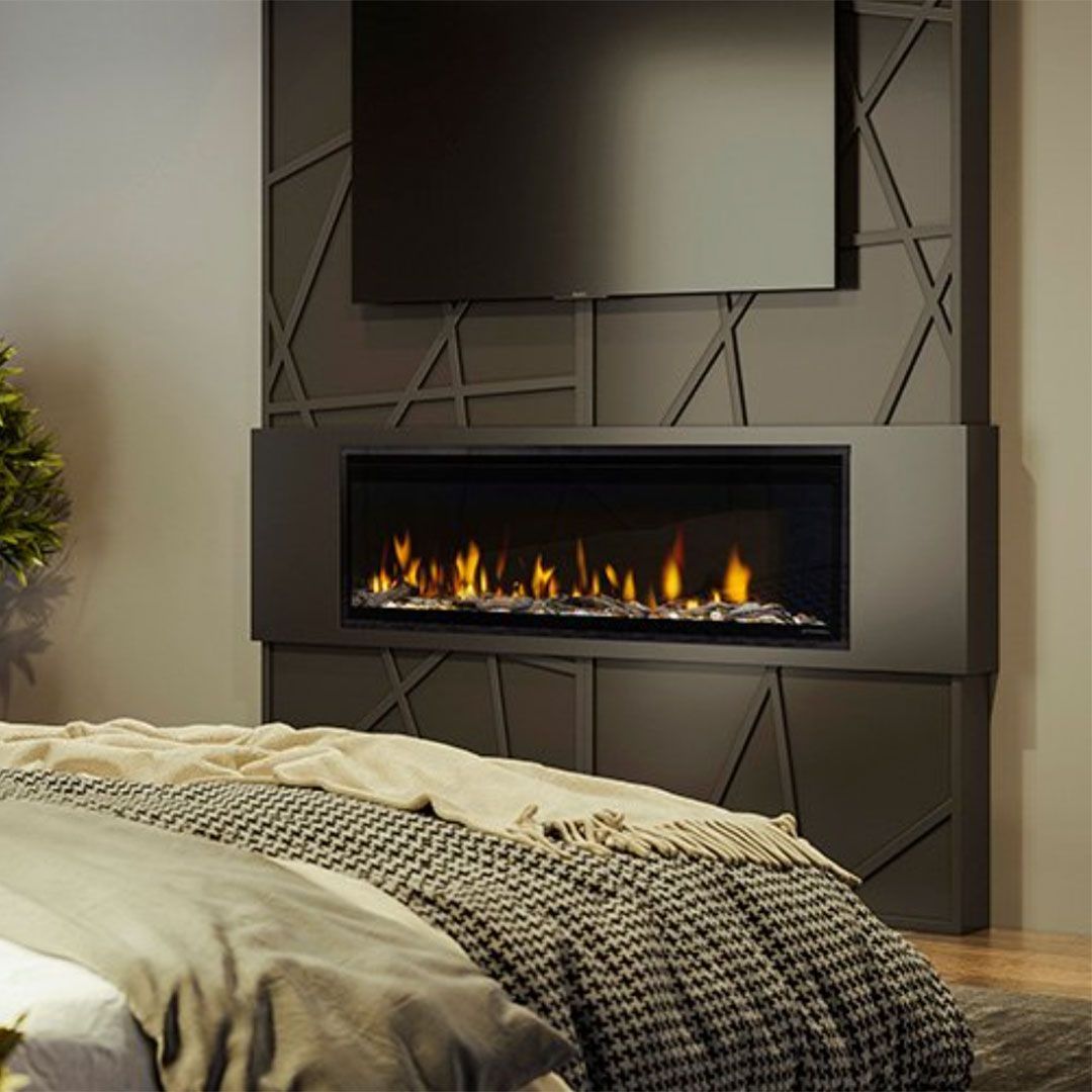 A bedroom with a fireplace and a flat screen tv.