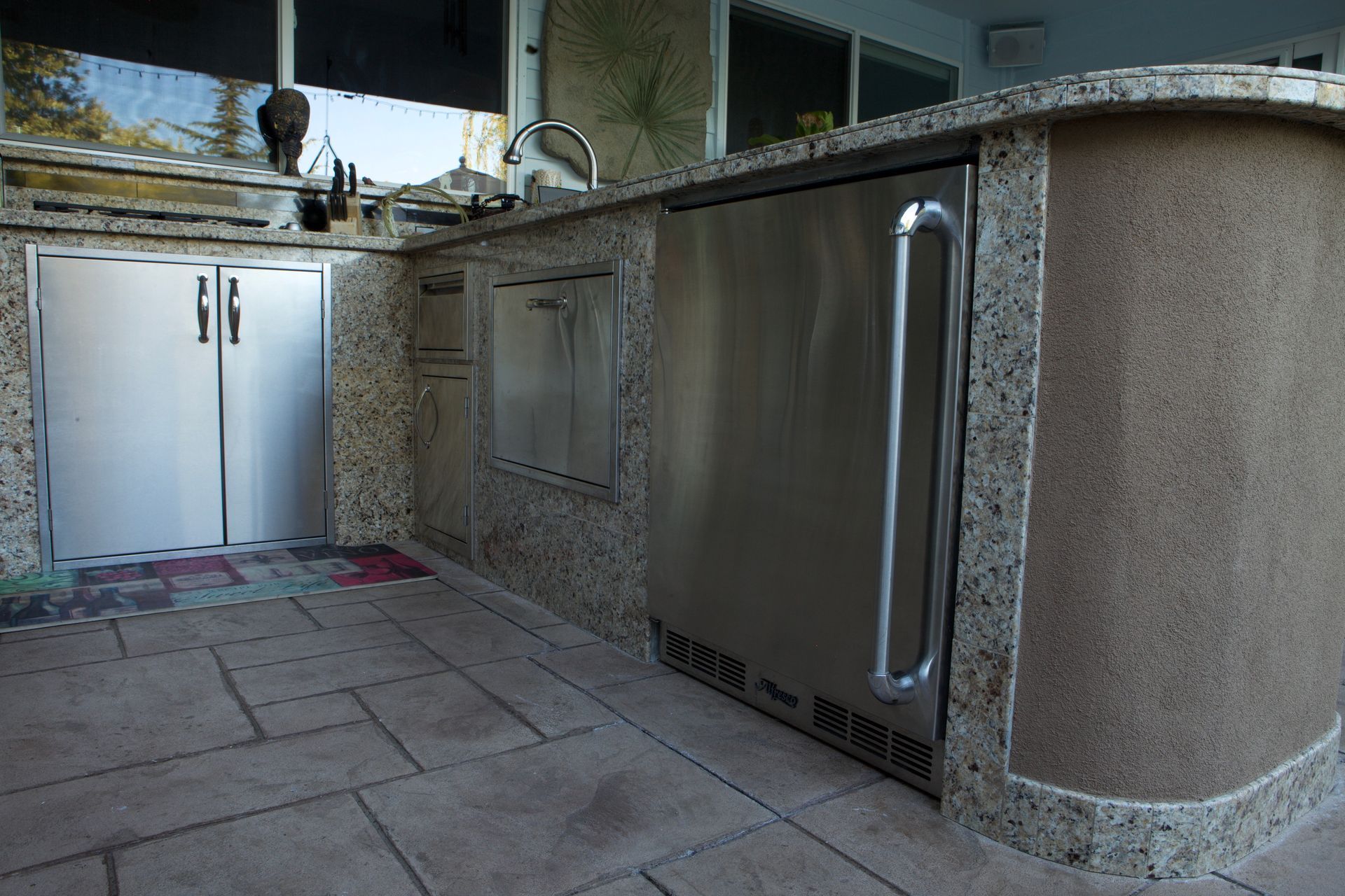 A kitchen with granite counter tops and stainless steel cabinets