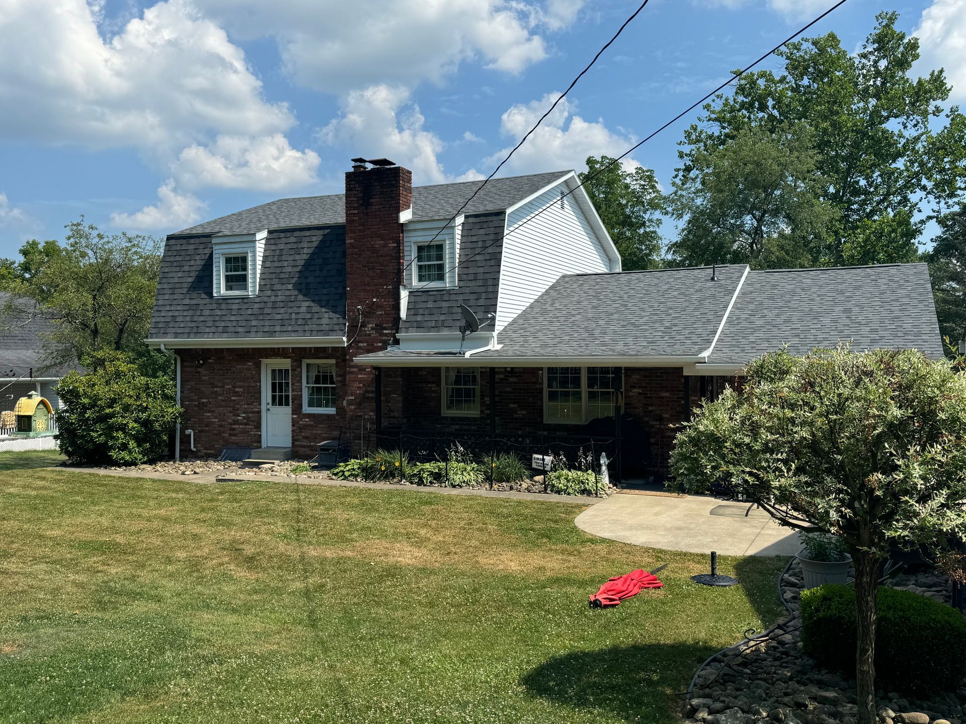 A large brick house with a gray roof and a chimney