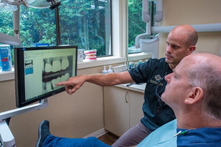 Dr. Robinson showing patient xrays after teeth cleaning | Lynnwood WA