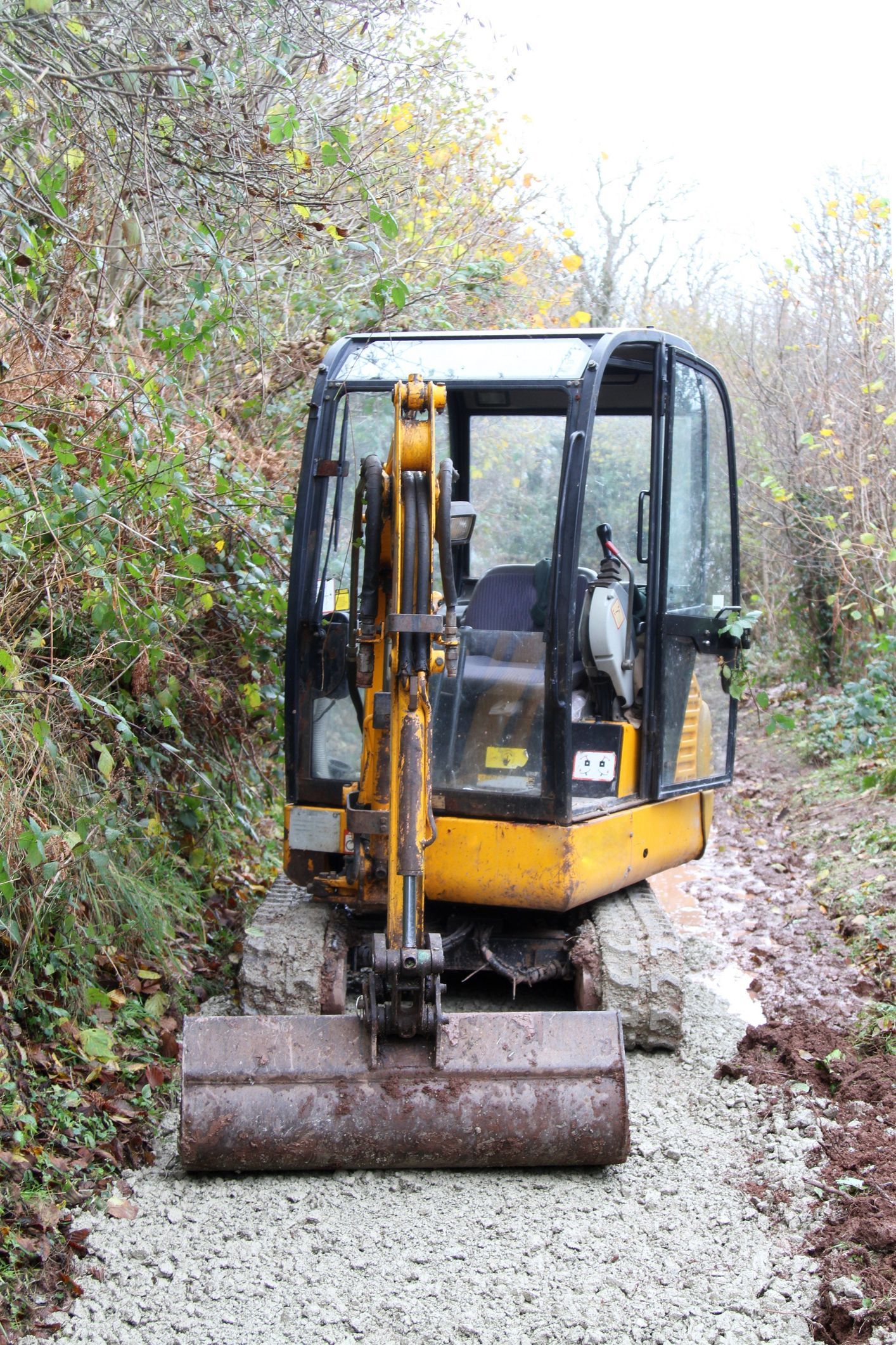 A close up of a yellow excavator bucket on a construction site.