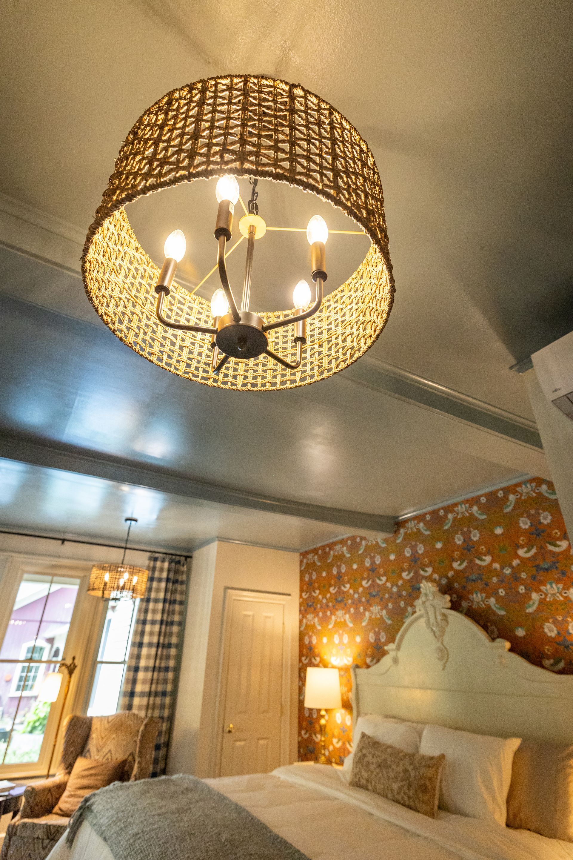 A bedroom with a bed and a chandelier hanging from the ceiling.