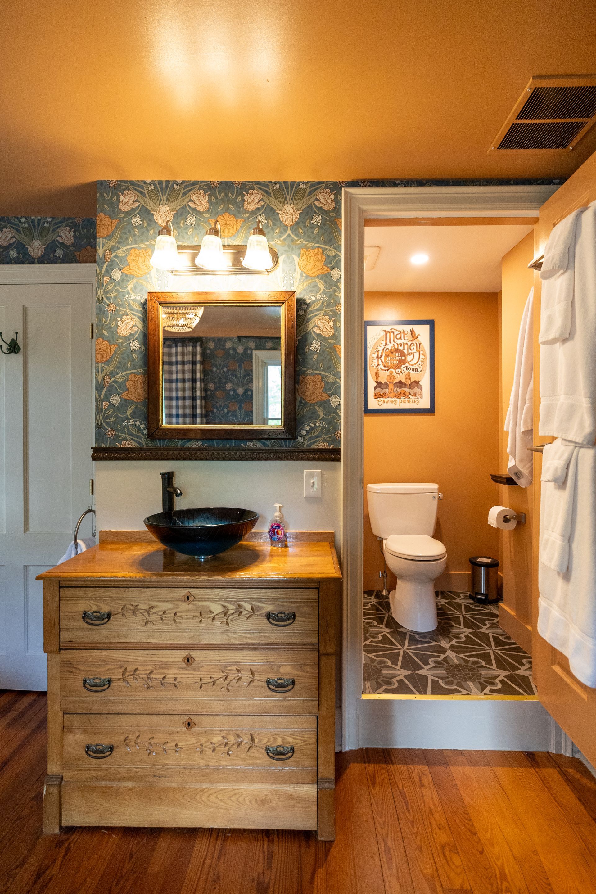 A bathroom with a sink , toilet and mirror.