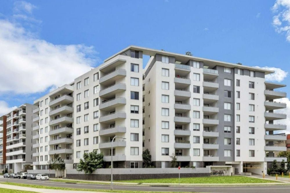 A large apartment building with a lot of balconies on a sunny day.