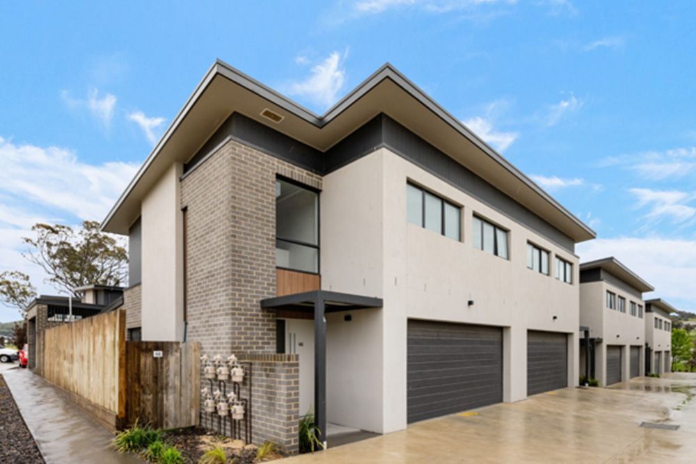 A large house with a lot of garages and a fence in front of it.