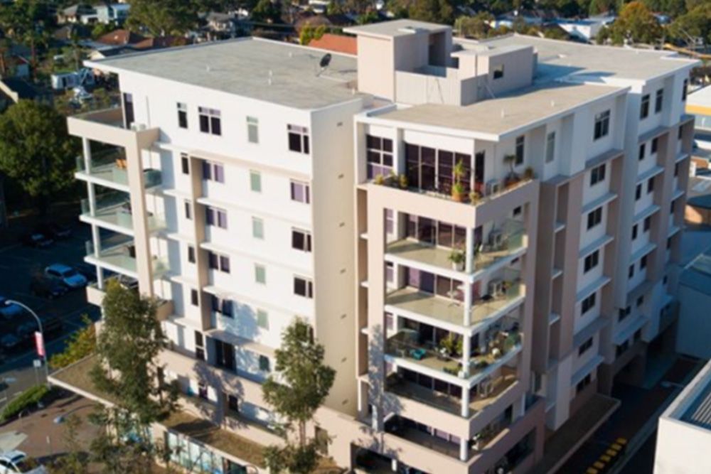 An aerial view of a large apartment building in a city.