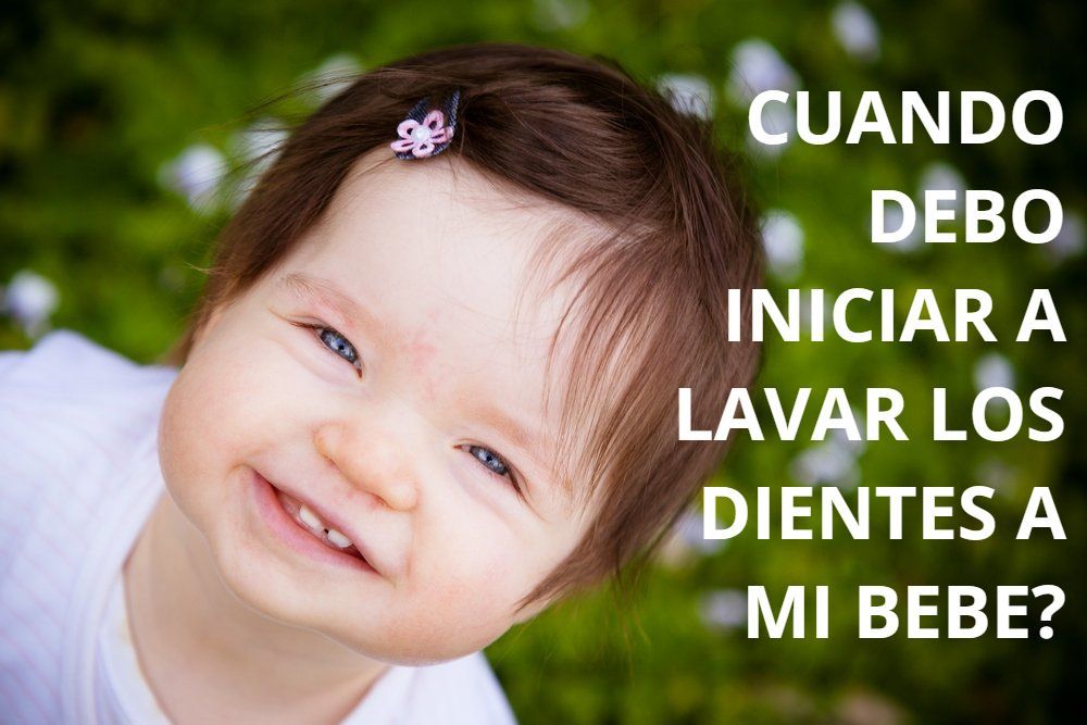 A baby girl is smiling with the words cuando debo iniciar a lavar los dientes a mi bebe