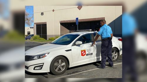 Security guard in blue uniform opening the door of a white security car with logo on the side in a parking lot. Elk Grove, CA — Airborne Security Patrol, Inc. Security guard in blue uniform opening the door of a white security car with logo on the side in a parking lot. Elk Grove, CA — Airborne Security Patrol, Inc.