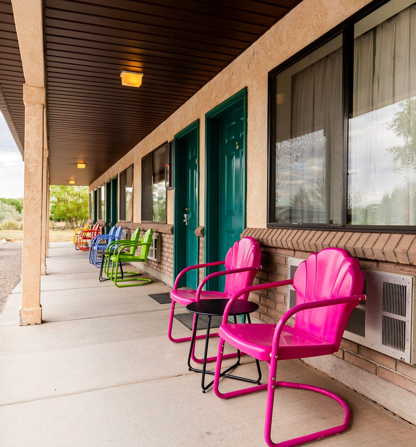 A row of colorful chairs on a porch of a building