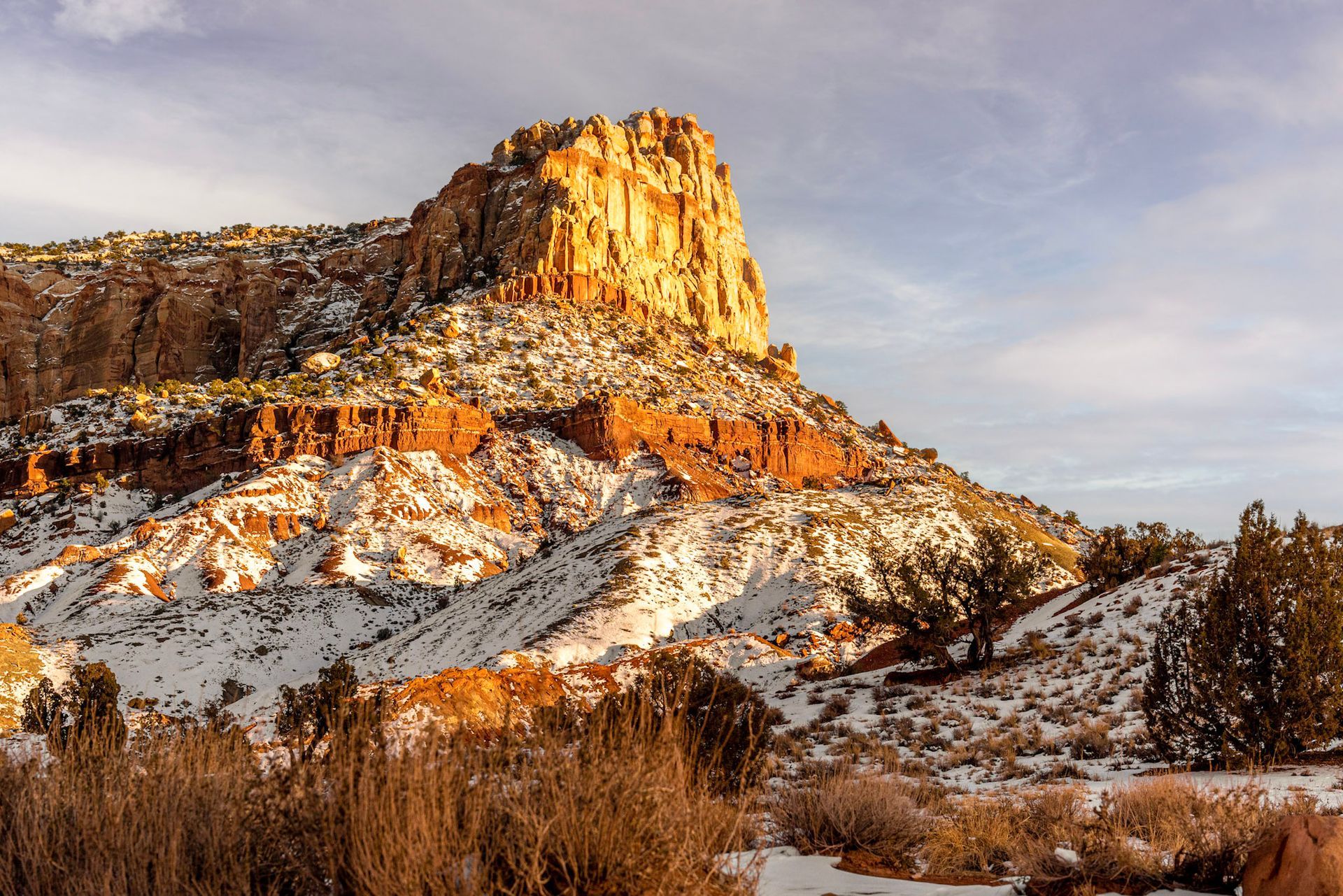 A large rocky mountain covered in snow and trees.