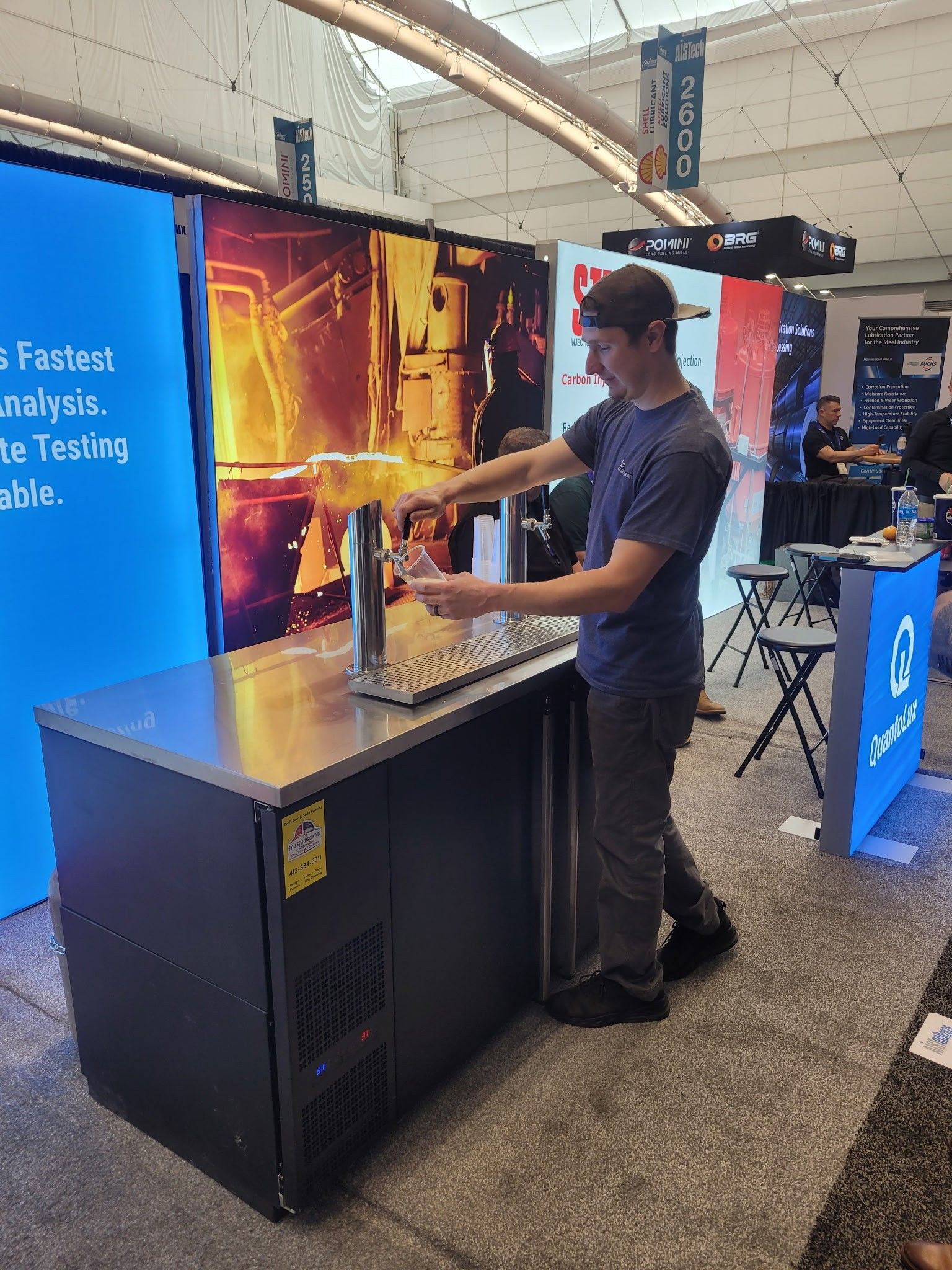 Man demonstrating a keg box at a trade show booth.