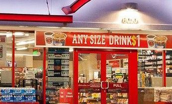 A convenience store with a sign that says any size drinks $ 1