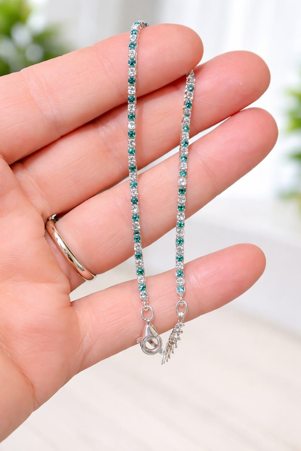 Pulsera de plata con piedras azul verdosas en la muñeca