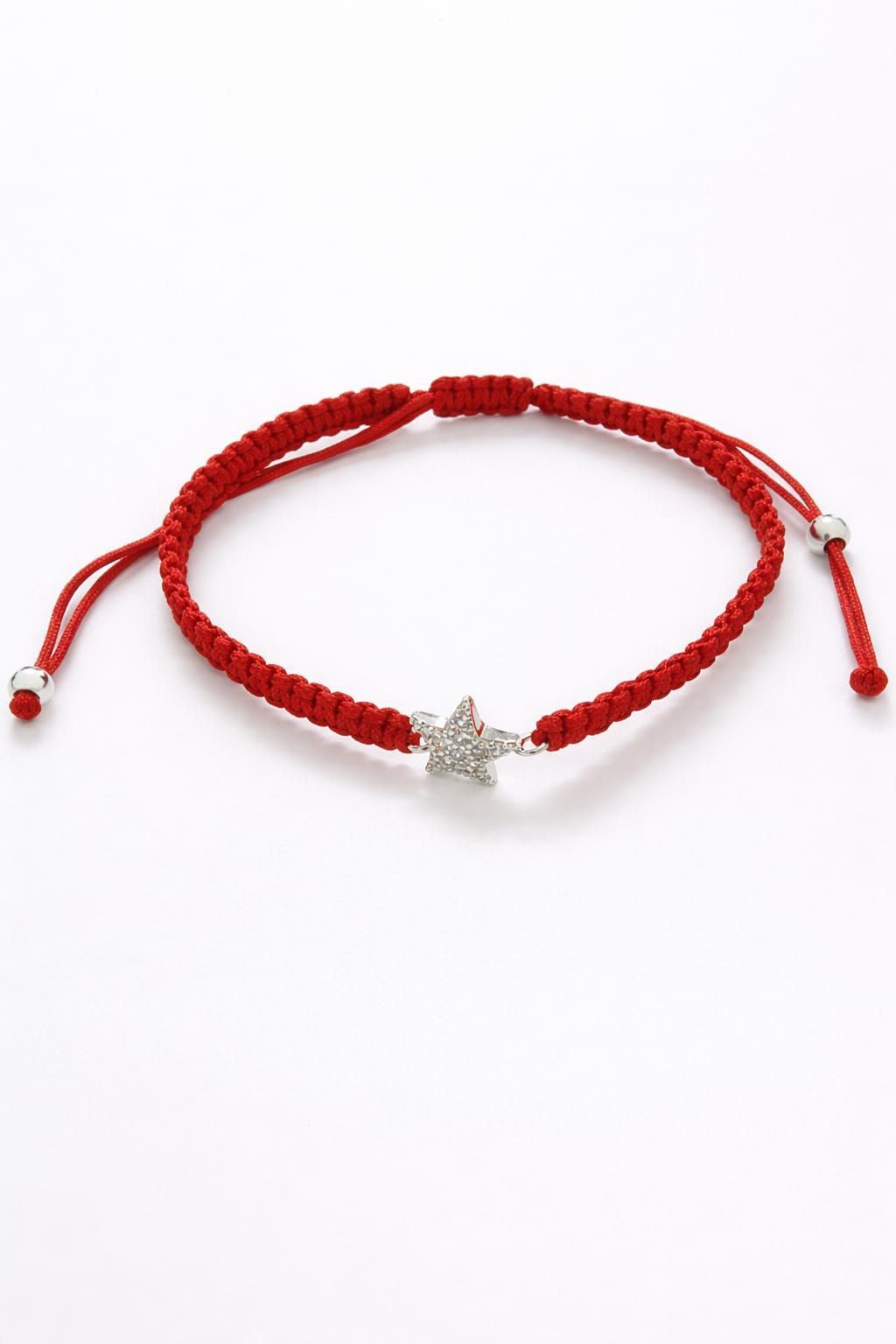 Pulsera trenzada roja con un dije de estrella plateada en la muñeca.