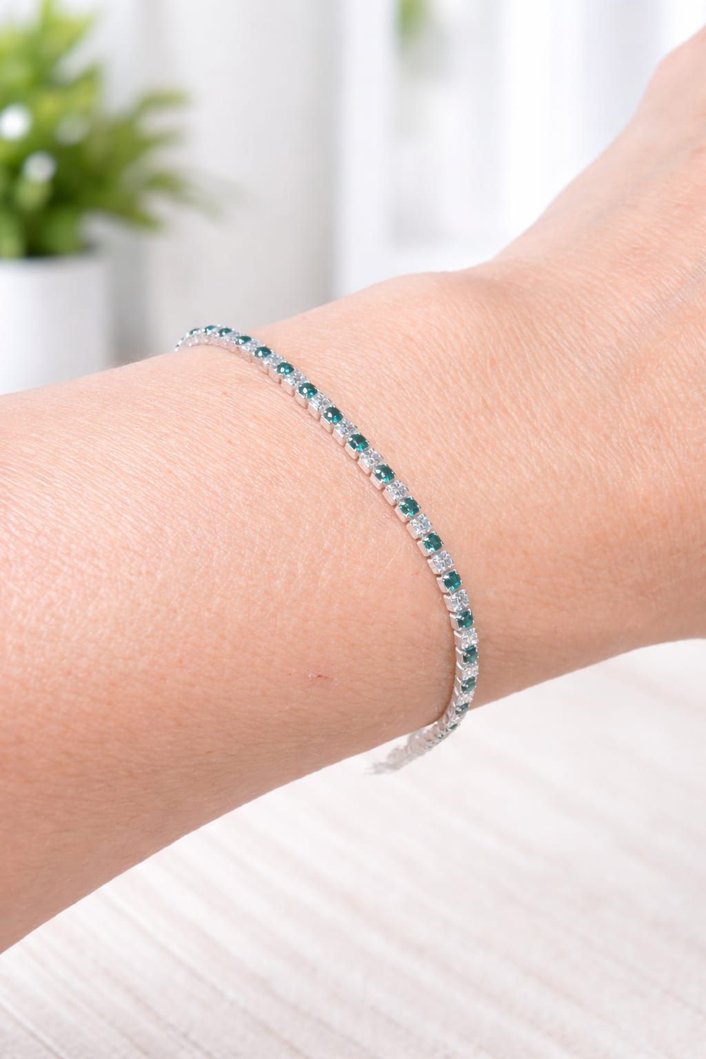Pulsera de plata con piedras azul verdosas en la muñeca