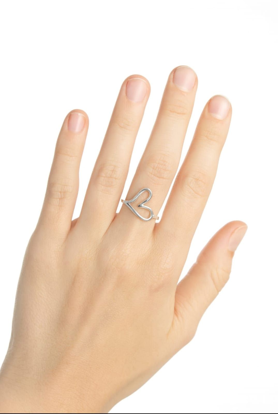 Mano con un anillo de mariposa de plata sobre fondo blanco