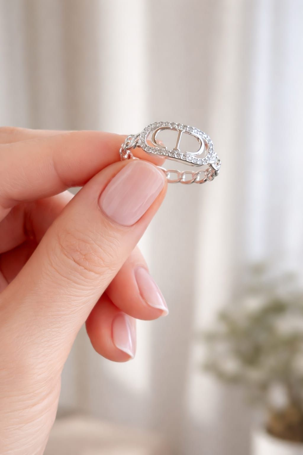 Un anillo de diamantes en un joyero blanco sobre una mesa con decoración en tonos beige suaves.
