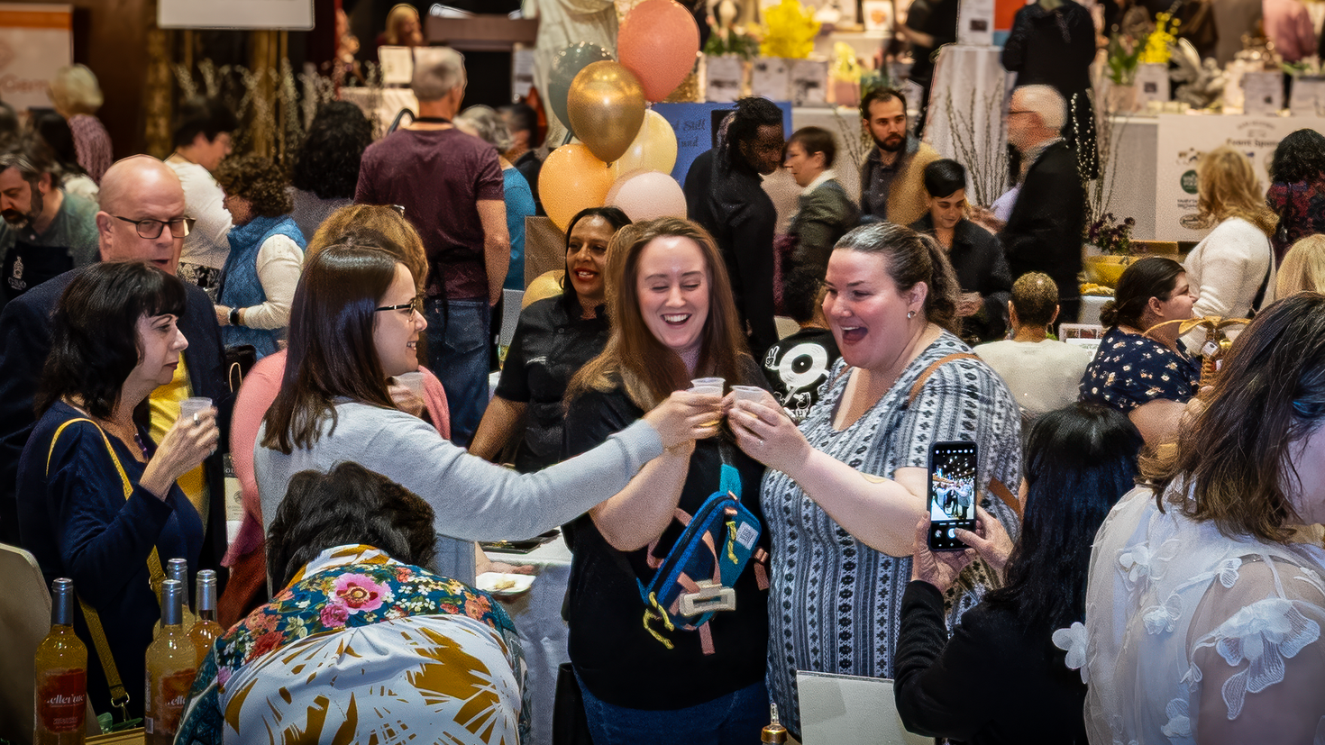 People dancing and mingling at a crowded indoor celebration with balloons and festive decorations