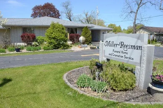 Miller-Reesman Funeral Home sign beside a landscaped brick building and driveway