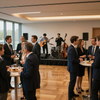 La gente socializa en un evento formal de networking en un espacio cerrado mientras una banda toca en vivo en el escenario.