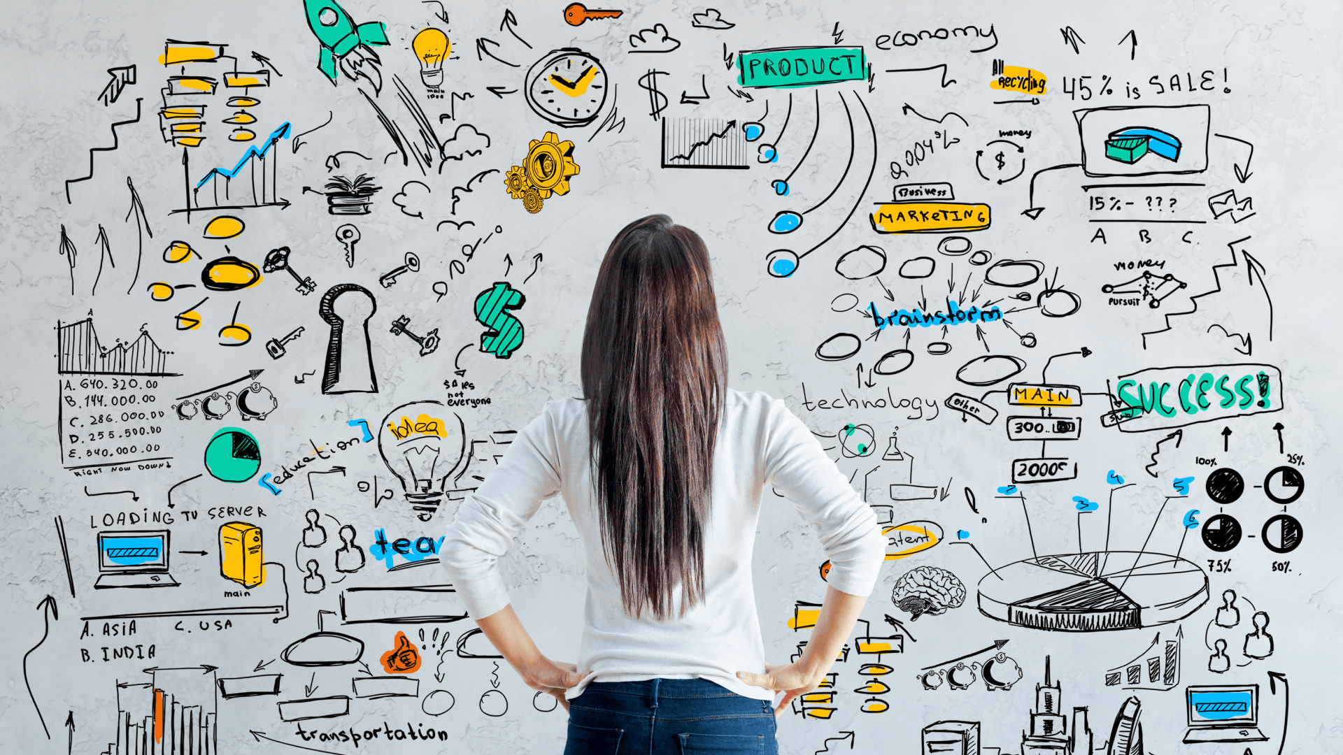 A woman is standing in front of a wall with drawings on it.