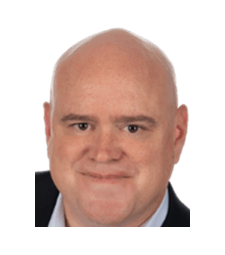 Headshot of a bald person in a dark suit with a slight smile on a white background
