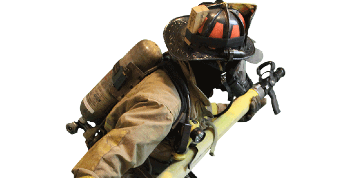 A firefighter holding and pointing a hose 