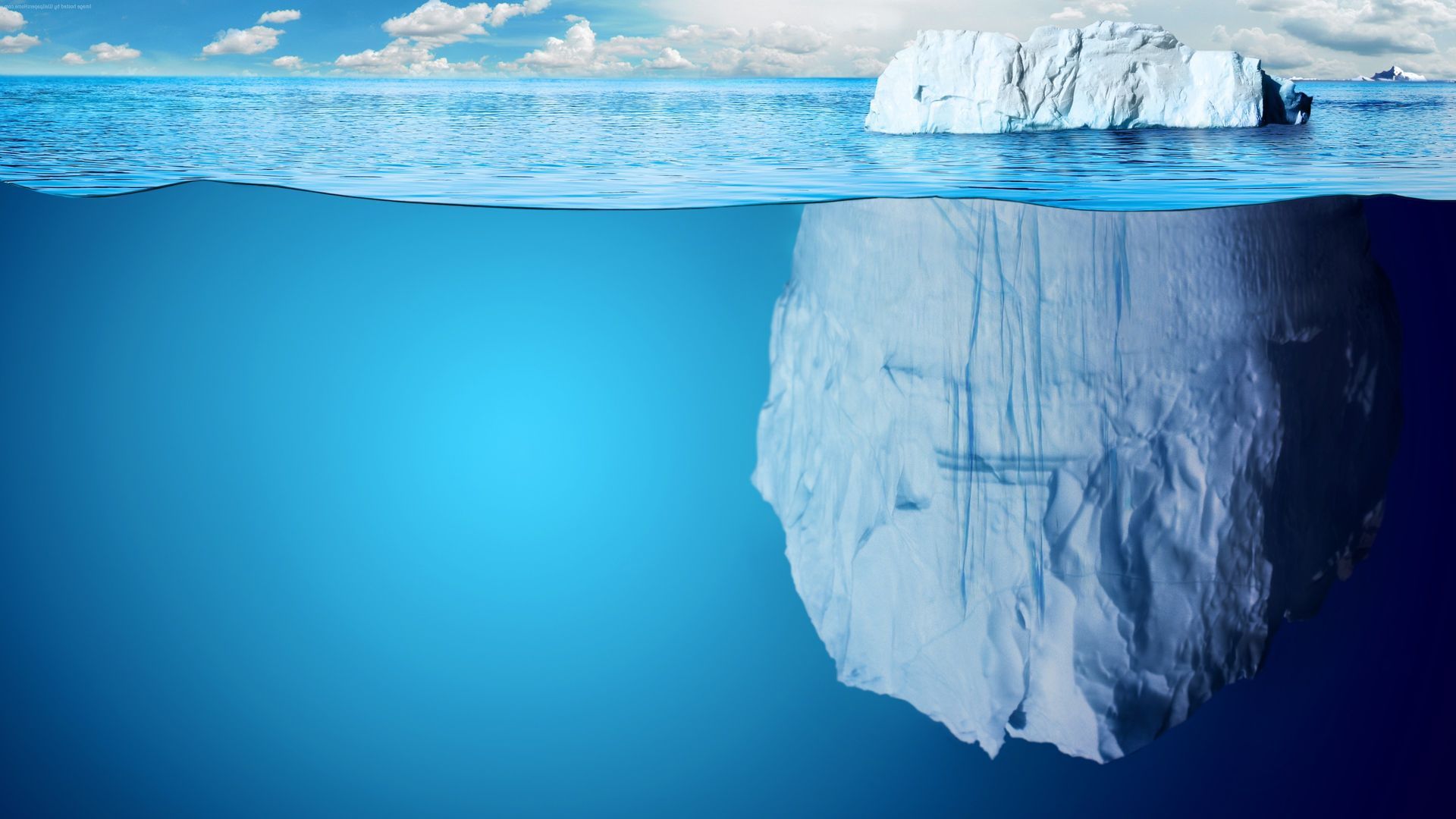 A partially submerged iceberg peeks through the top of the water