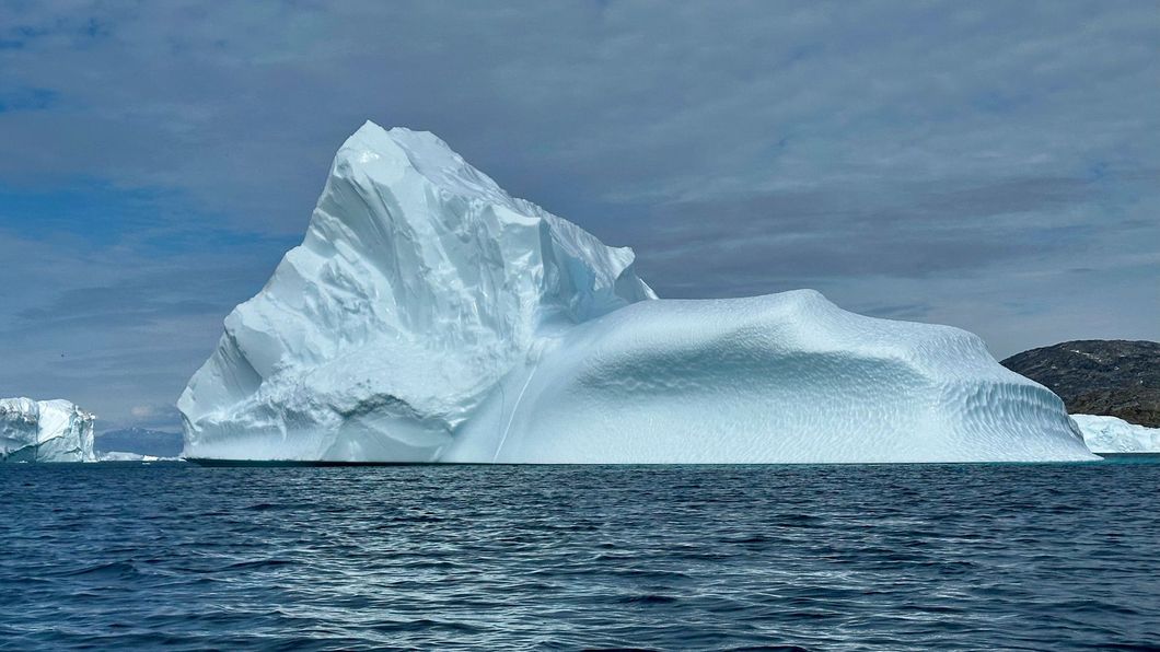 Iceberg floating in a deep blue ocean, with most of its mass hidden underwater.