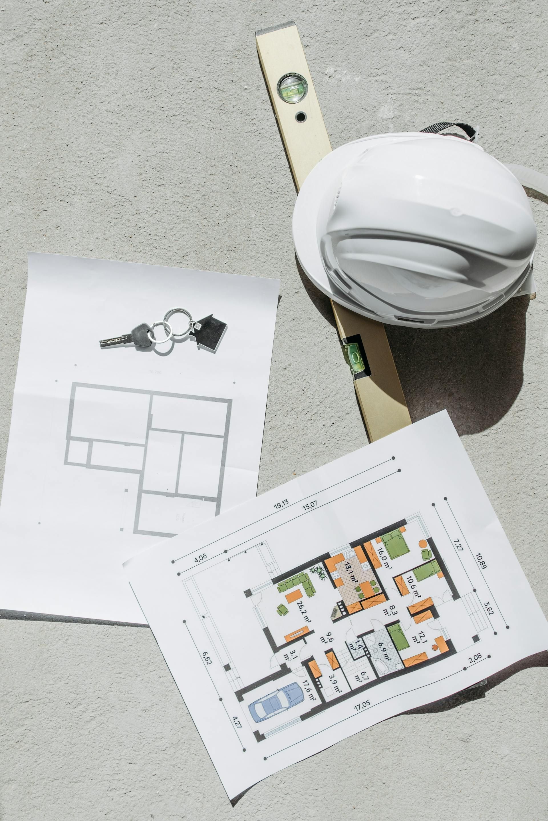 pic of construction hat, leveler, and construction documents