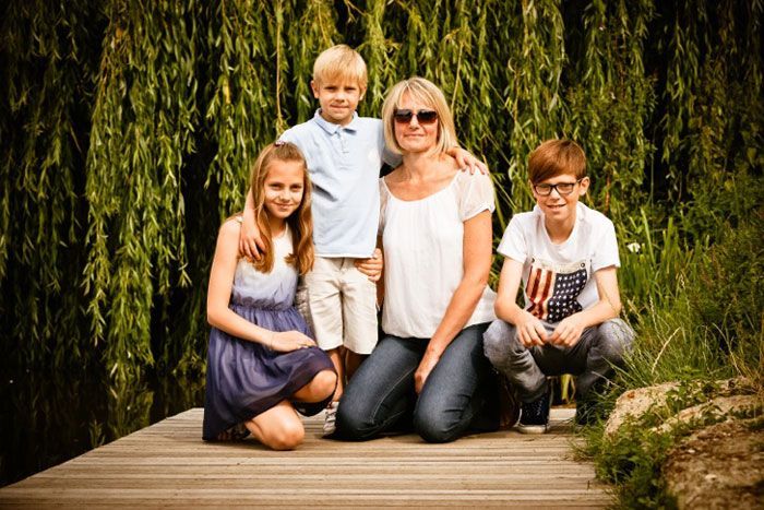 A family is posing for a picture on a wooden dock.