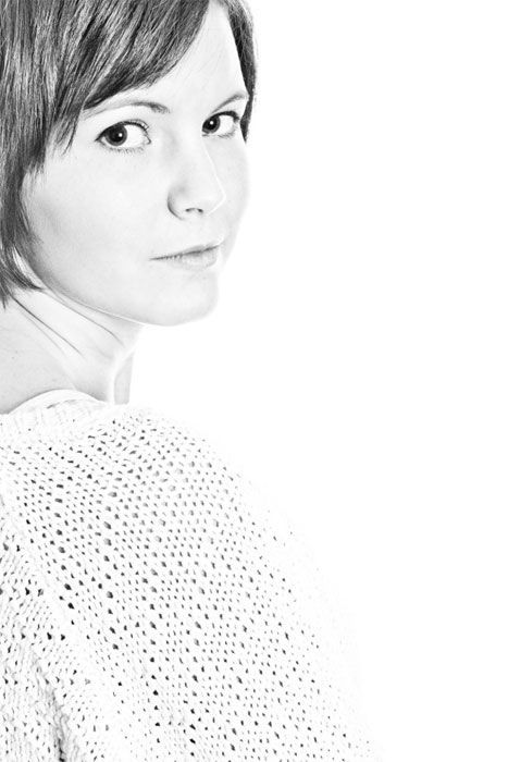 A black and white photo of a woman wearing a white sweater.