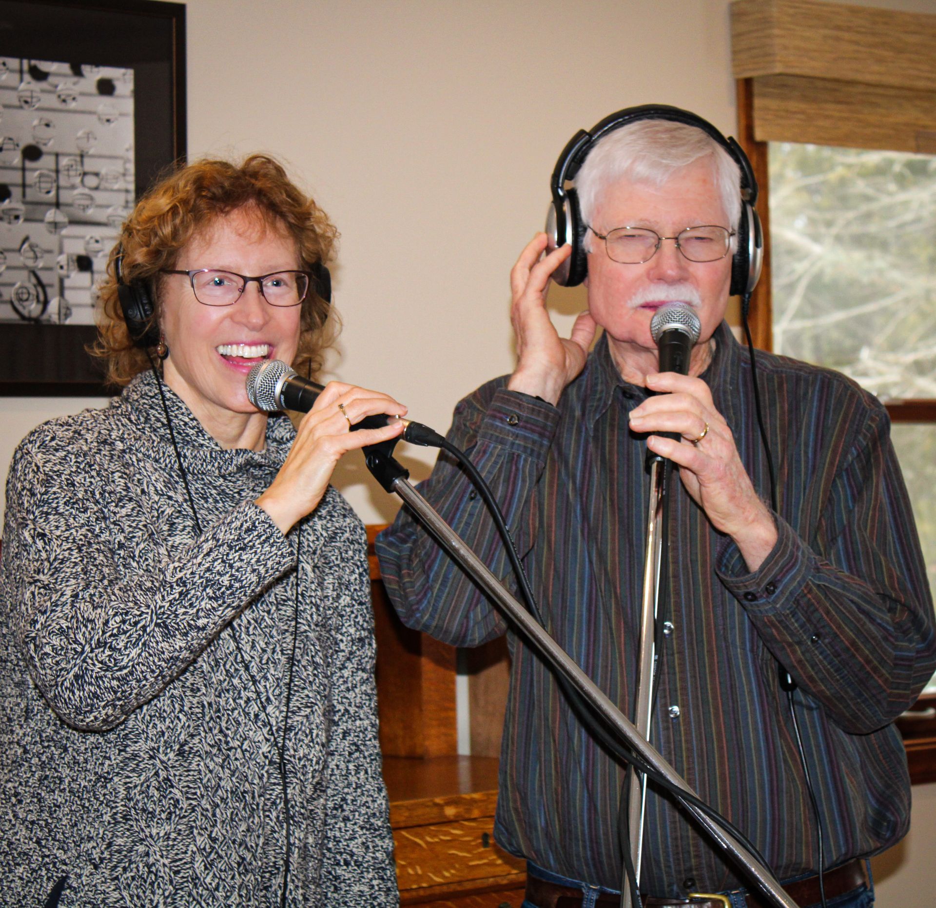 Two men harmonizing with headphones on performing at isham family farm