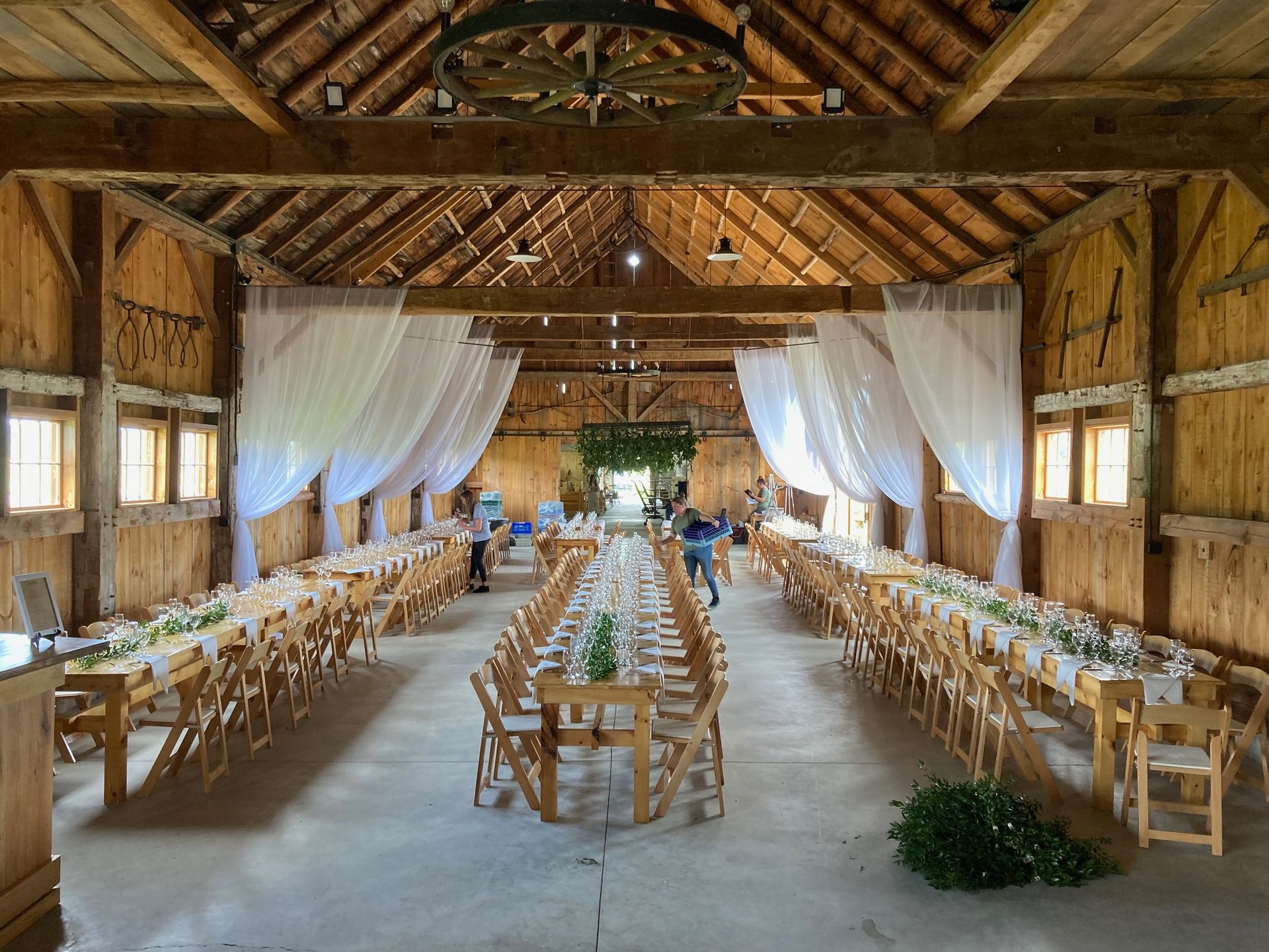 table settings for a wedding reception inside the isham family farm barn in vermont