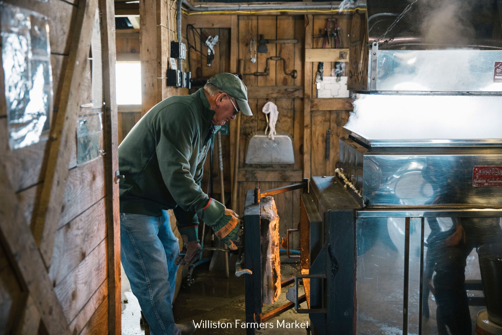 Isham family member tending to the fire in the maple boiling shack