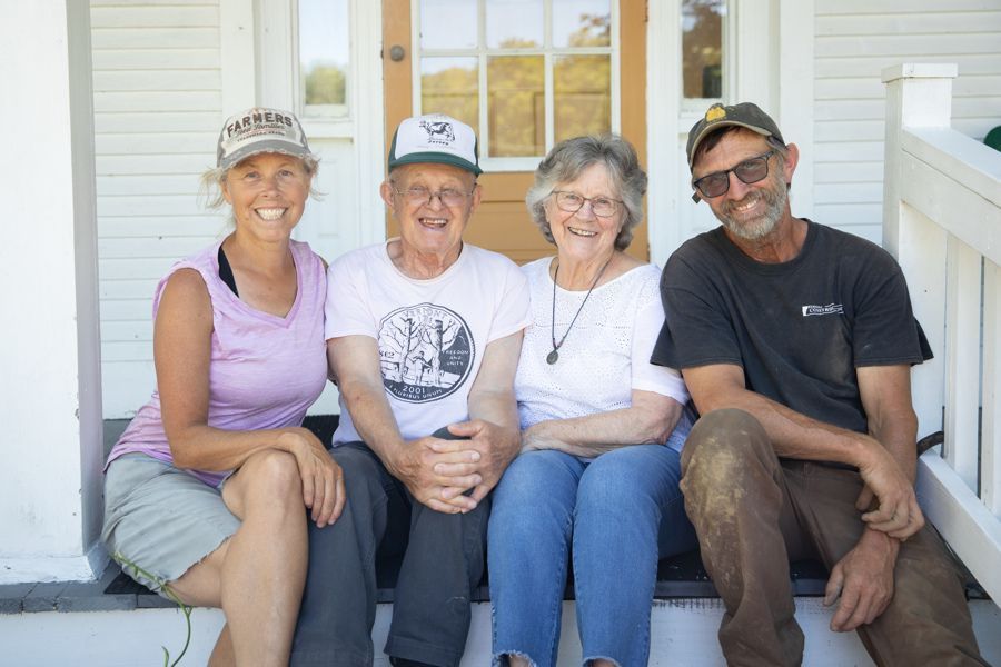 four members of the isham family on the steps of the main house on the farm in vermont