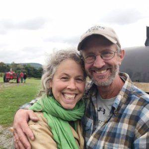 Mike and Helen Isham smiling together on the family farm in Williston, Vermont.